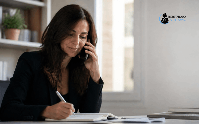 Profesional atendiendo llamada de cliente en despacho con agenda